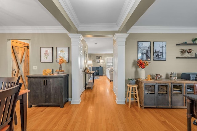 corridor with ornate columns, crown molding, and light hardwood / wood-style floors