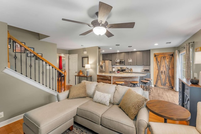 living room with ceiling fan and light hardwood / wood-style flooring