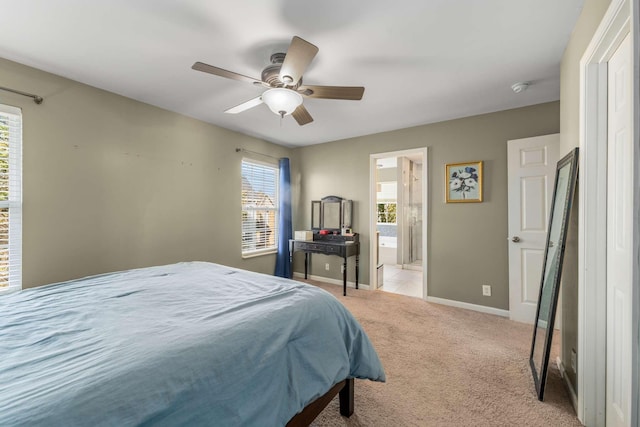 bedroom featuring light carpet, ensuite bath, and ceiling fan