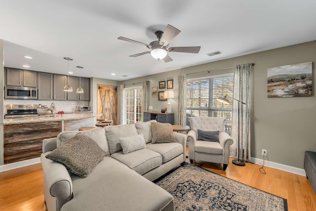 living room featuring ceiling fan and light hardwood / wood-style flooring