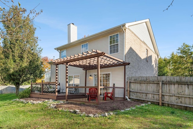 rear view of property featuring a pergola, a lawn, and a wooden deck