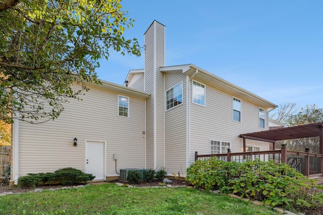 back of property featuring a lawn and a deck