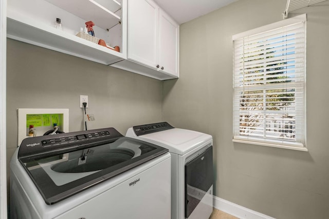 washroom featuring washer and dryer and cabinets