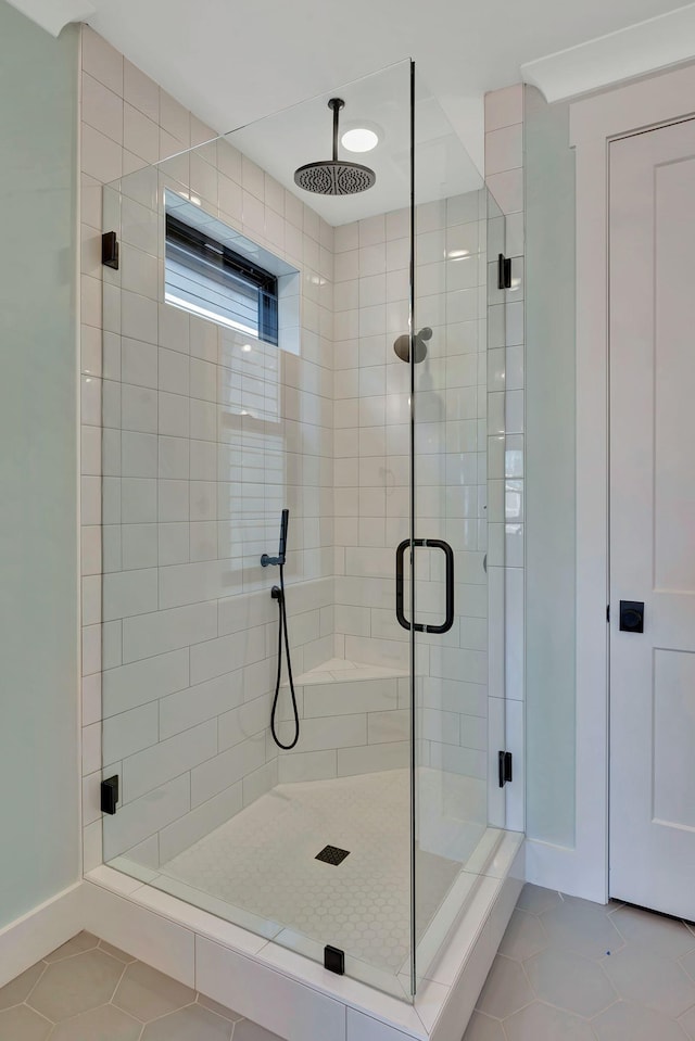 bathroom featuring an enclosed shower and tile patterned floors