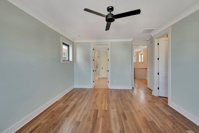 empty room with light hardwood / wood-style floors, ornamental molding, and ceiling fan