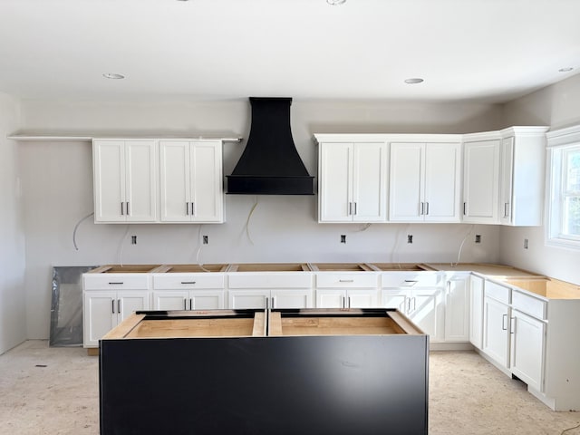 kitchen featuring white cabinets and custom range hood