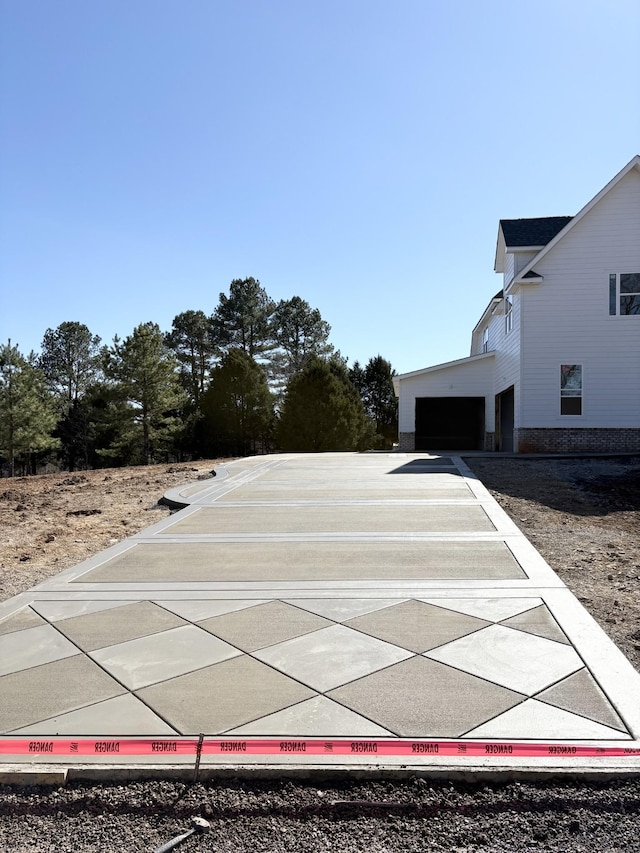 view of yard with a garage and driveway