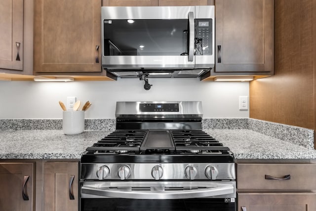 kitchen featuring light stone counters and appliances with stainless steel finishes