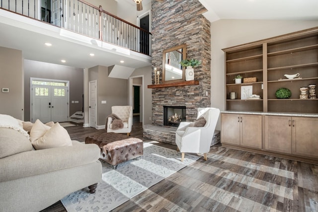 living room with a fireplace, high vaulted ceiling, and dark hardwood / wood-style floors