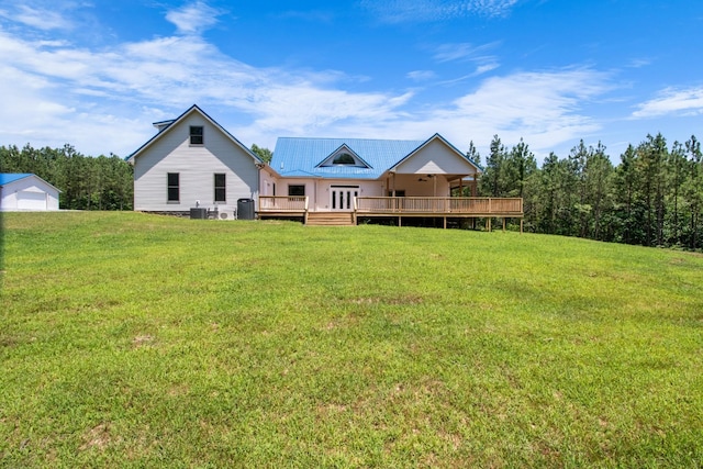 back of property with central air condition unit, a deck, and a lawn