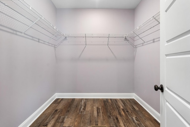 spacious closet with dark hardwood / wood-style floors