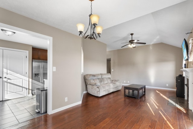 unfurnished living room featuring ceiling fan with notable chandelier, wood-type flooring, and lofted ceiling