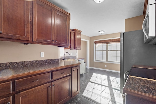 kitchen featuring sink, light tile patterned floors, and stainless steel appliances