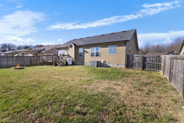 back of property with a yard, a wooden deck, and central air condition unit