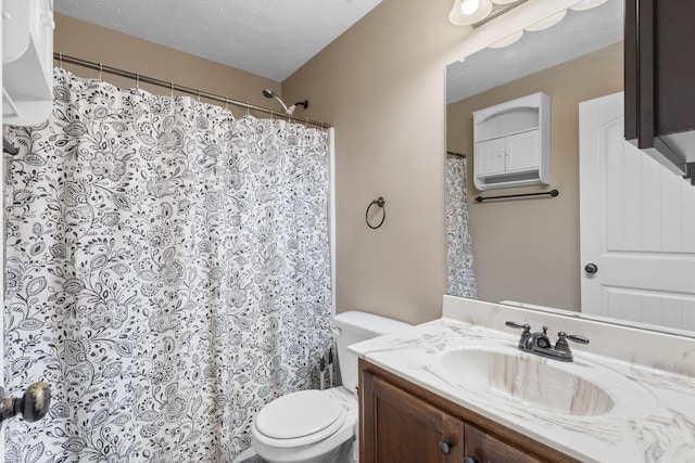 bathroom with vanity, a textured ceiling, and toilet