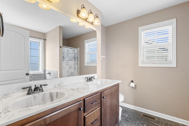 bathroom with walk in shower, vanity, and toilet