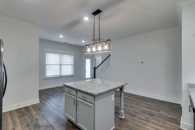 kitchen with a kitchen bar, a center island, decorative light fixtures, and dark hardwood / wood-style floors