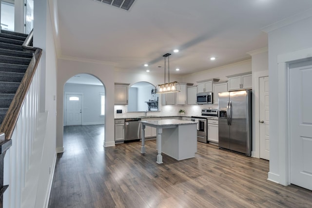 kitchen featuring a kitchen breakfast bar, stainless steel appliances, pendant lighting, dark hardwood / wood-style floors, and a kitchen island