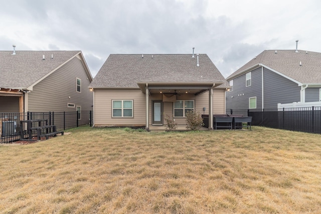 back of house with ceiling fan and a lawn