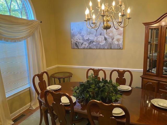 dining space featuring hardwood / wood-style flooring and an inviting chandelier