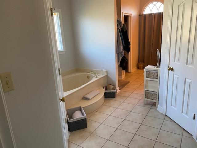 bathroom featuring a tub to relax in and tile patterned floors