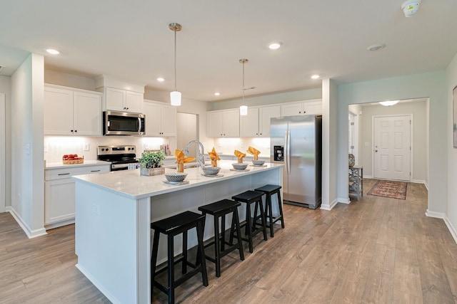 0 Larry Cir, Mount Pleasant, TN 38474 - kitchen with stainless steel appliances, light wood finished floors, a kitchen breakfast bar, light countertops, and white cabinets