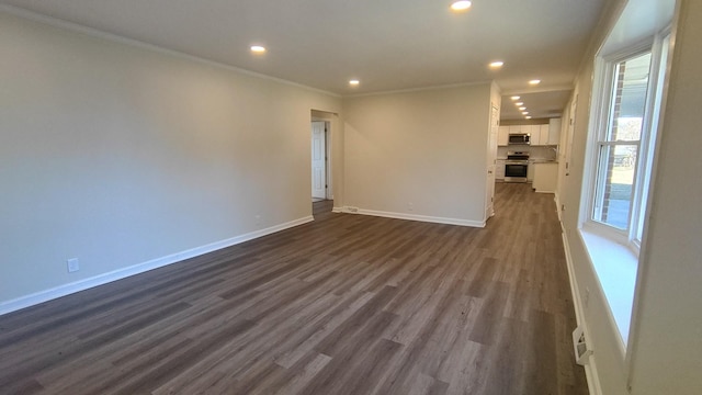 spare room with ornamental molding and dark wood-type flooring