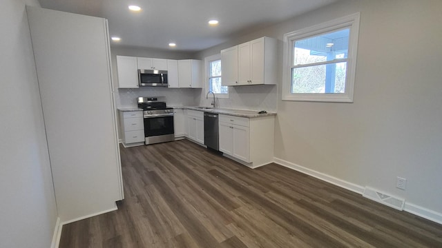 kitchen with sink, white cabinetry, dark wood-type flooring, and appliances with stainless steel finishes