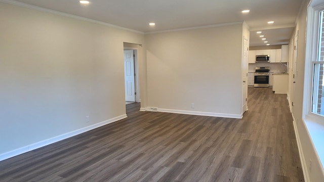 empty room featuring dark hardwood / wood-style floors, crown molding, and sink