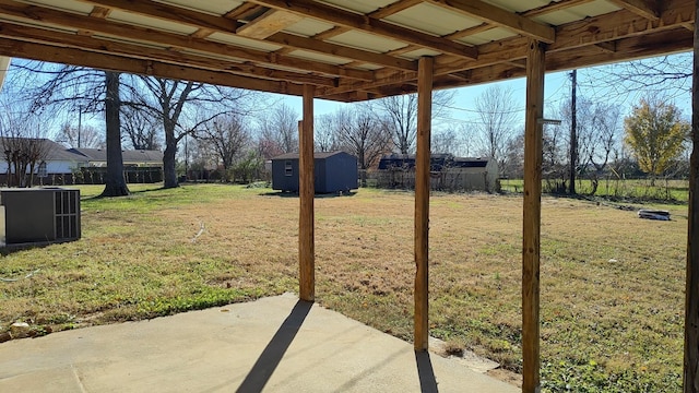 view of yard featuring cooling unit, a storage unit, and a patio area