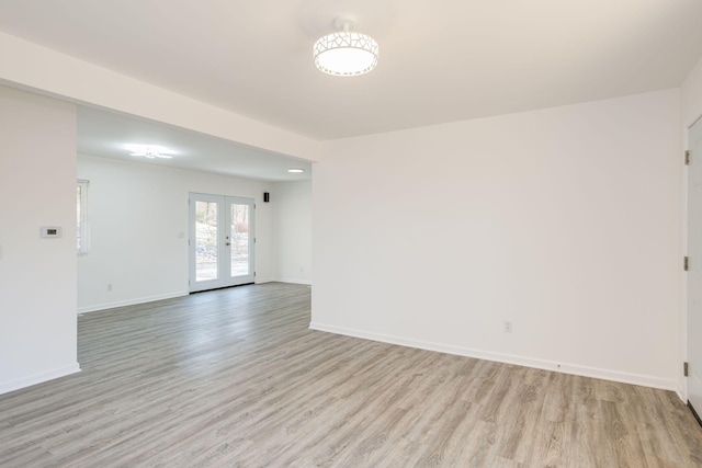 spare room with french doors and light hardwood / wood-style flooring