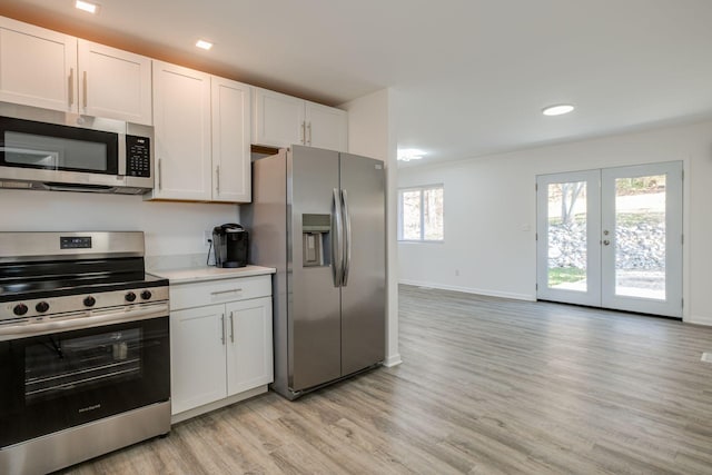 kitchen with white cabinets, french doors, appliances with stainless steel finishes, and light hardwood / wood-style flooring