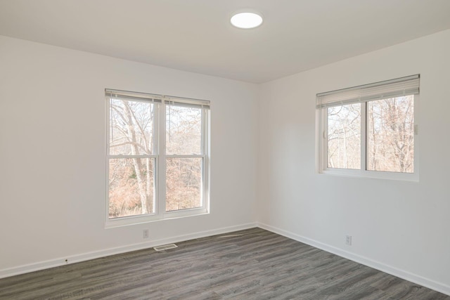 unfurnished room with dark hardwood / wood-style floors and plenty of natural light