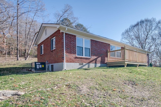 view of side of property with a lawn, a wooden deck, and central AC