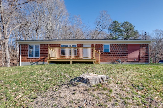 rear view of property featuring a deck and a lawn