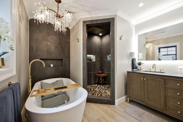 bathroom featuring vanity, an inviting chandelier, crown molding, hardwood / wood-style flooring, and separate shower and tub