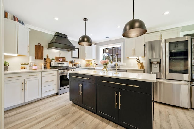 kitchen featuring light wood-type flooring, custom exhaust hood, stainless steel appliances, white cabinetry, and hanging light fixtures