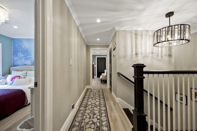 hall featuring a notable chandelier, ornamental molding, and light hardwood / wood-style flooring