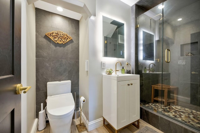 bathroom with hardwood / wood-style flooring, a shower with door, vanity, and toilet