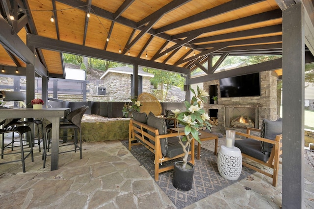 view of patio featuring a gazebo and an outdoor stone fireplace