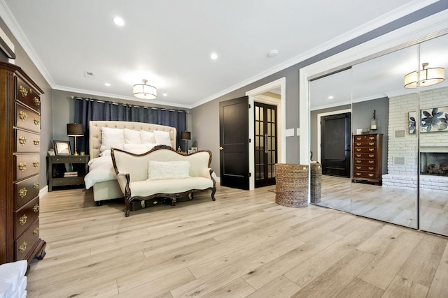 bedroom with a fireplace, light wood-type flooring, and ornamental molding