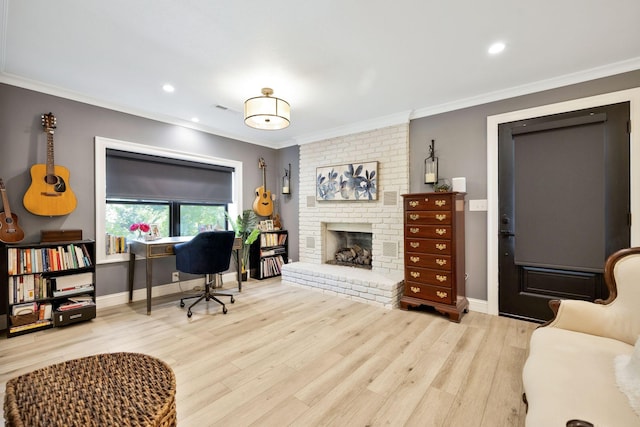 office with a brick fireplace, crown molding, and light hardwood / wood-style flooring