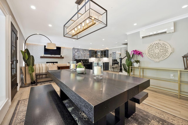 dining room with a large fireplace, wood-type flooring, crown molding, and a wall unit AC