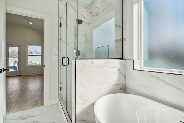 bathroom featuring hardwood / wood-style floors, separate shower and tub, and vaulted ceiling