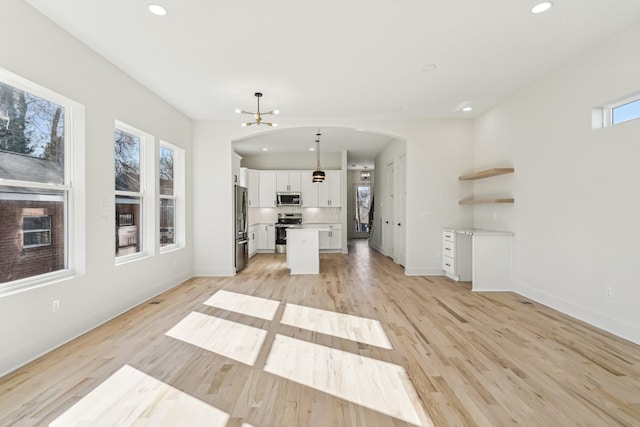 unfurnished living room featuring light hardwood / wood-style floors and a notable chandelier