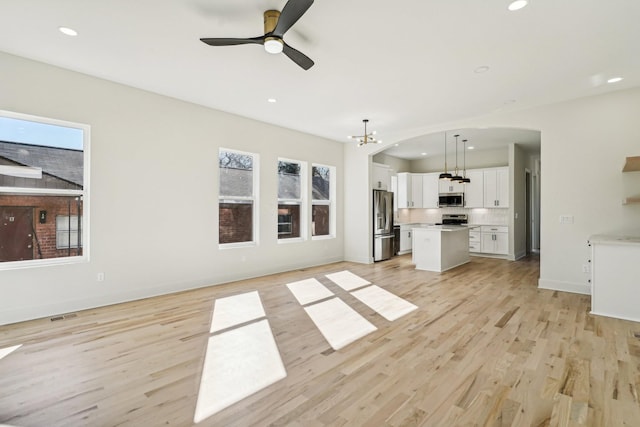 unfurnished living room featuring light hardwood / wood-style floors and ceiling fan with notable chandelier