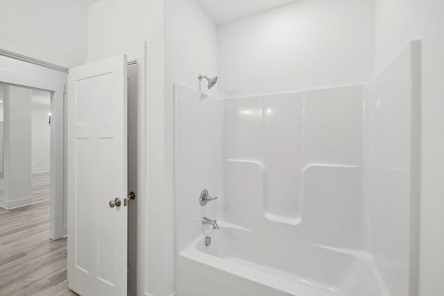 bathroom with hardwood / wood-style flooring and tub / shower combination