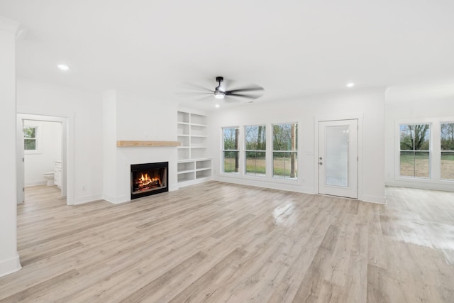 unfurnished living room with light hardwood / wood-style flooring, ceiling fan, and a healthy amount of sunlight