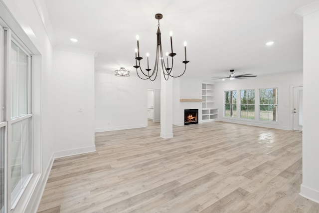 unfurnished living room featuring ceiling fan with notable chandelier, light hardwood / wood-style floors, and built in features