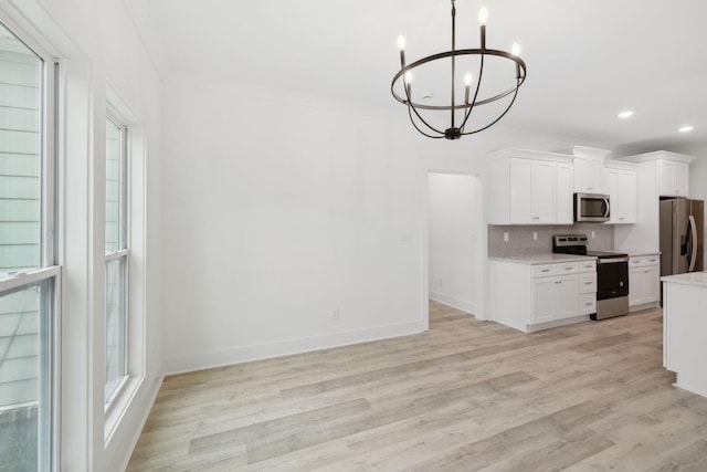 kitchen featuring light hardwood / wood-style flooring, white cabinets, stainless steel appliances, and a notable chandelier